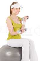 Fitness teenager woman with dumbbell sit on ball