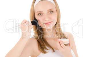 Facial care teenager woman apply powder with brush