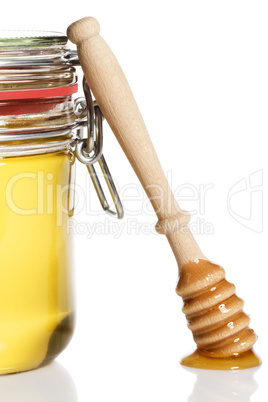 honiglöffel lehnt an einem glas mit honig
