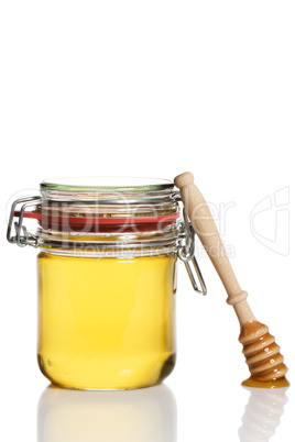 honiglöffel lehnt an einem glas mit honig