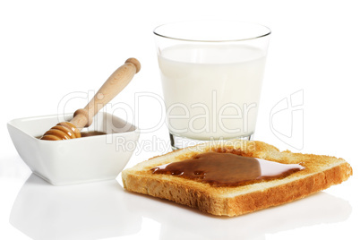 honig auf einem toast mit milch und einem honiglöffel in einer schale mit honig