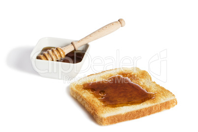 toast mit honig und einer schale honig mit einem honiglöffel