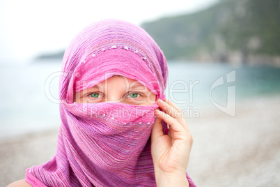 Beautiful girl with face covered by red scarf