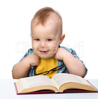 Little child play with book and glasses