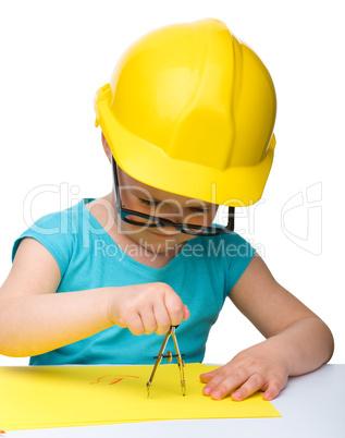 Little girl is playing while wearing hard hat