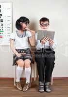 Two person wearing spectacles in an office at the doctor