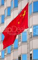 Nationalflagge von China vor moderner Fensterfront