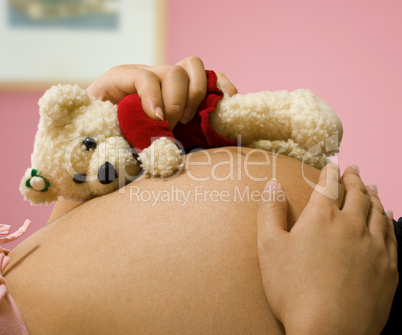 Pregnant Mother Holding A Teddy Bear