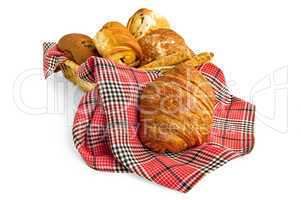 Croissant and muffins in a basket with a napkin