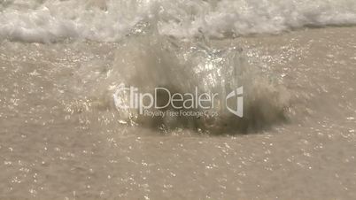 Wellen unterspülen das Strandufer