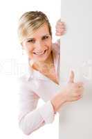 Happy businesswoman behind empty banner thumbs up
