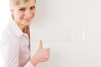 Happy businesswoman behind empty banner thumbs up