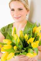 Young woman hold yellow tulips flower