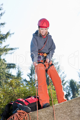 Active woman rock climbing holding rope