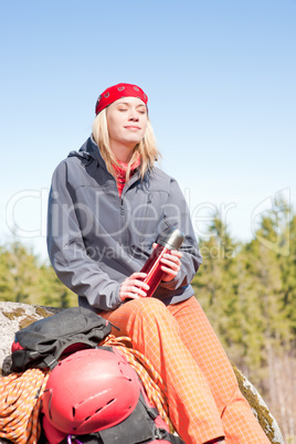 Active woman rock climbing relax with thermobottle