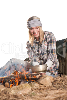 Hiking woman with backpack cook by campfire