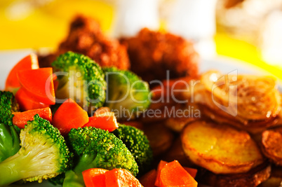 Fried potatoes broccoli carrots and roasted chicken