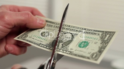A dollar bill being cut in half