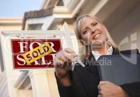 Real Estate Agent with Keys in Front of Sold Sign and House