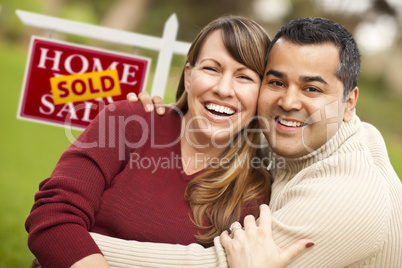 Mixed Race Couple in Front of Sold Real Estate Sign