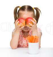 Cute little girl with carrot and apples