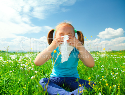 Little girl is blowing her nose