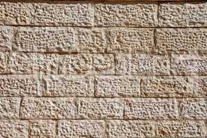 Wall built of rough beige stone blocks