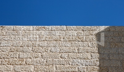 Upward view of beige stone wall