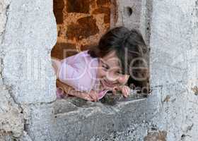 Smiling girl eans out of the castle window