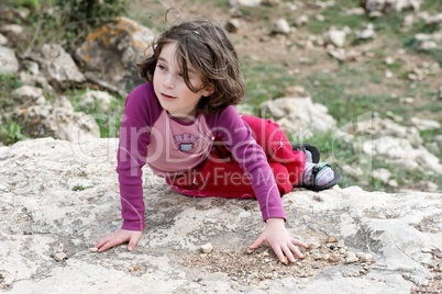 Little girl lies on the rock