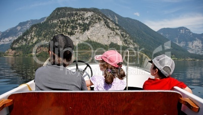 Mother with 2 kids ride a motor boat on the lake