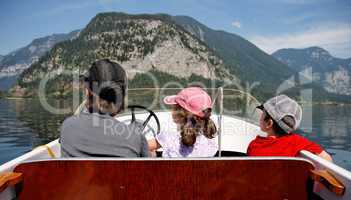 Mother with 2 kids ride a motor boat on the lake