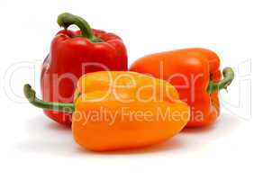 Three sweet bell peppers in red, orange and yellow colors on white background