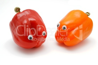 Two sweet bell peppers with eyes on white background