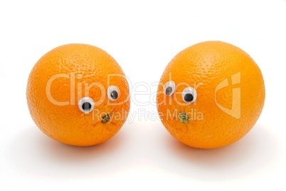 Two funny orange fruits with eyes on white background