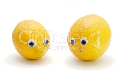 Two funny lemon fruits with eyes on white background