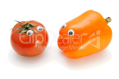Red tomato and orange bellpepper with eyes on white background
