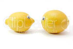 Two funny lemon fruits with eyes on white background