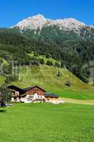 Alpine chalets and meadows under the mountains