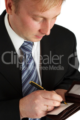 The businessman in a black suit signs a paper.
