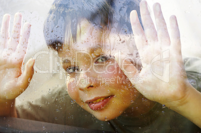 child and window on a wet rainy day