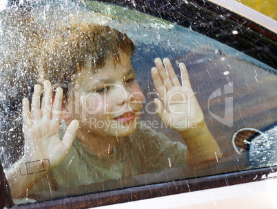 child and window on a wet rainy day