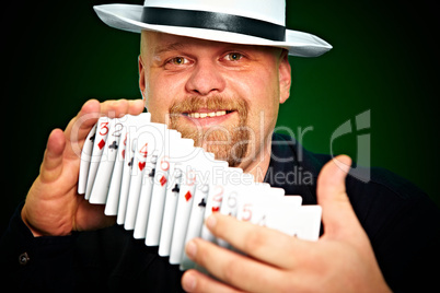man skilfully shuffles playing cards
