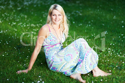 junge Frau in einem Sommerkleid auf einer Wiese