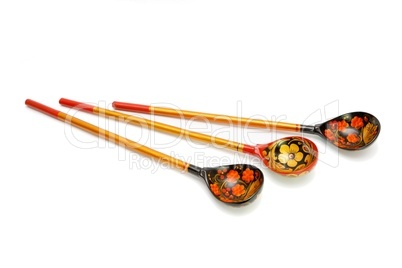 Three Russian wooden hand-painted spoons wih long handles on white background