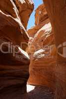 Narrow slot between two orange rocks in desert canyon