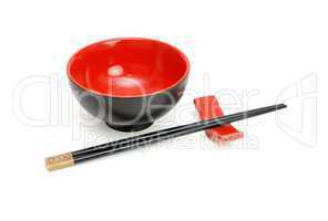Chopsticks on stand anongside the red and black Japanese bowl