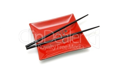 Chopsticks on  red square plate with kanji insrtiption isolated
