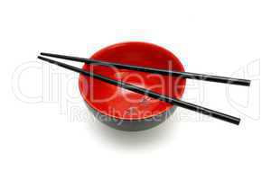 Chopsticks on  red and black bowl with kanji insrtiption isolated