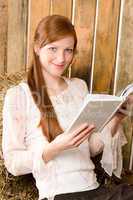 Young romantic woman in barn hold book